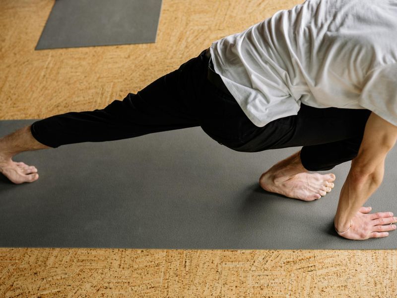Person doing a high-lunge yoga pose for strength.
