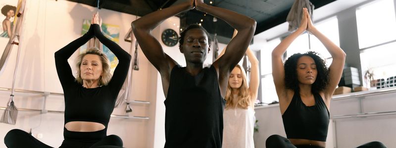 Silhouettes of people in a yoga class at sunset.
